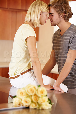Buy stock photo A young couple face-to-face in the kitchen