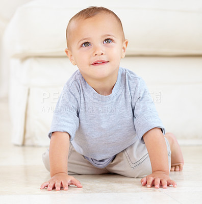 Buy stock photo Cute, sweet and young baby at his home playing for child development and growth. Face, youth and happy boy newborn, infant or kid having fun and crawling on the floor in living room of a modern house