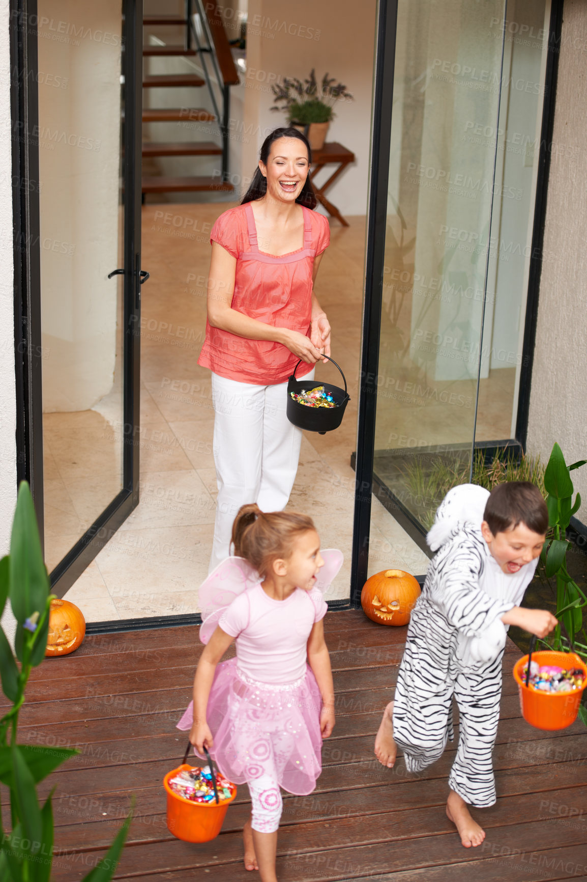 Buy stock photo Family house, halloween and children running with candy for fun adventure or vacation tradition. Happy, love and mom watching kids in costume with candy, laugh and energy in costume for holiday prank