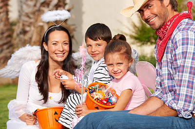 Buy stock photo Cropped shot of a family out the treats they've collected on Halloween
