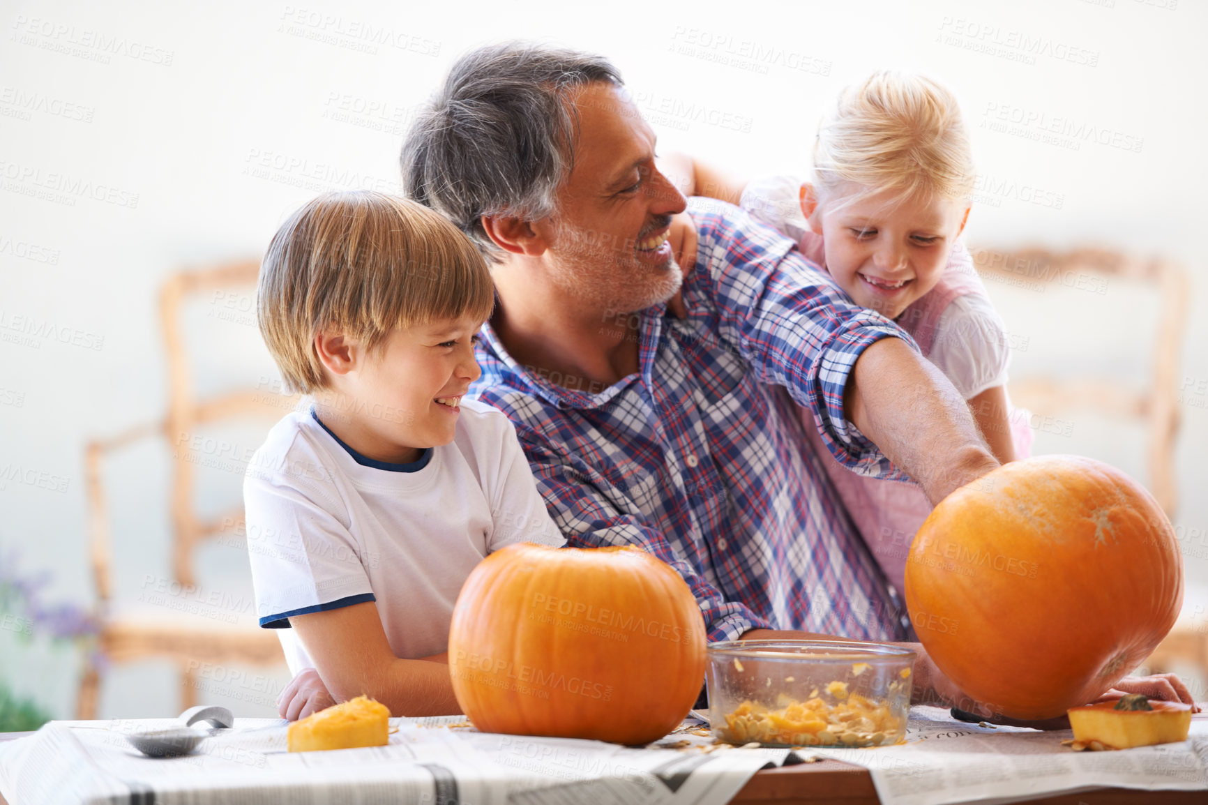 Buy stock photo Father, children and carving halloween pumpkins in home, happy family together and help. Dad, kids and vegetable for creative holiday decorations, party preparation and jack o lantern for celebration