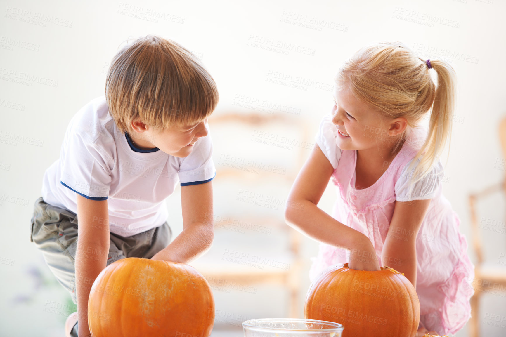 Buy stock photo Halloween, happy and carving a pumpkin with children at a home table for fun and bonding. Boy and girl or young kids as siblings together for creativity, holiday lantern and craft and play in a house