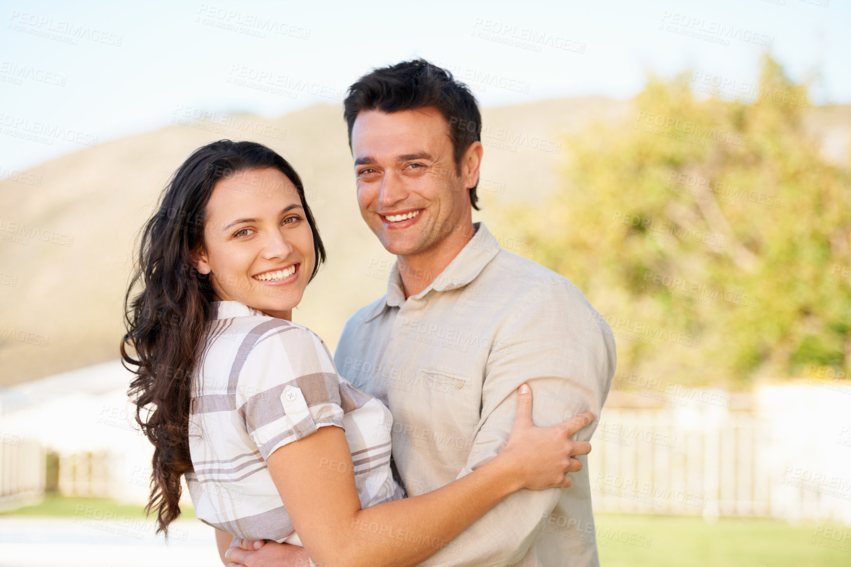 Buy stock photo A cute couple embracing outdoors