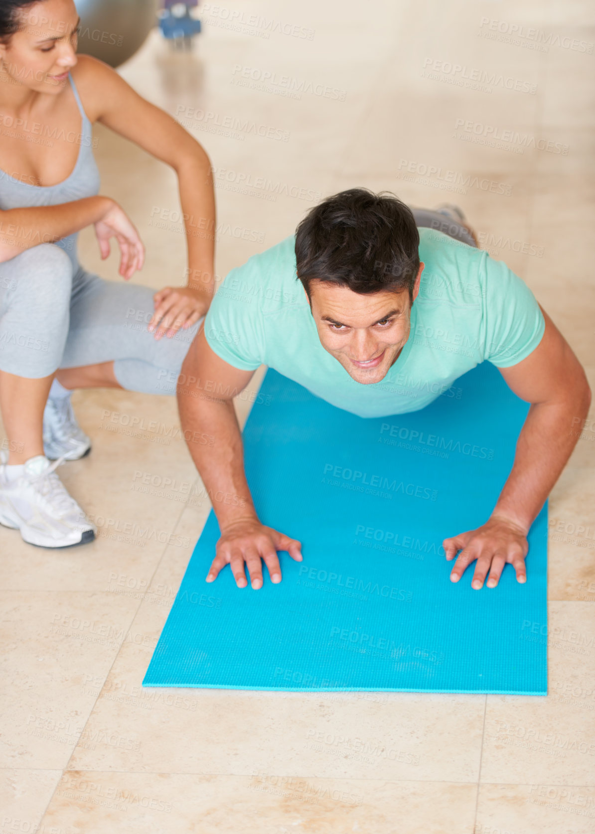 Buy stock photo A fitness instructor showing a young man how to do an exercise