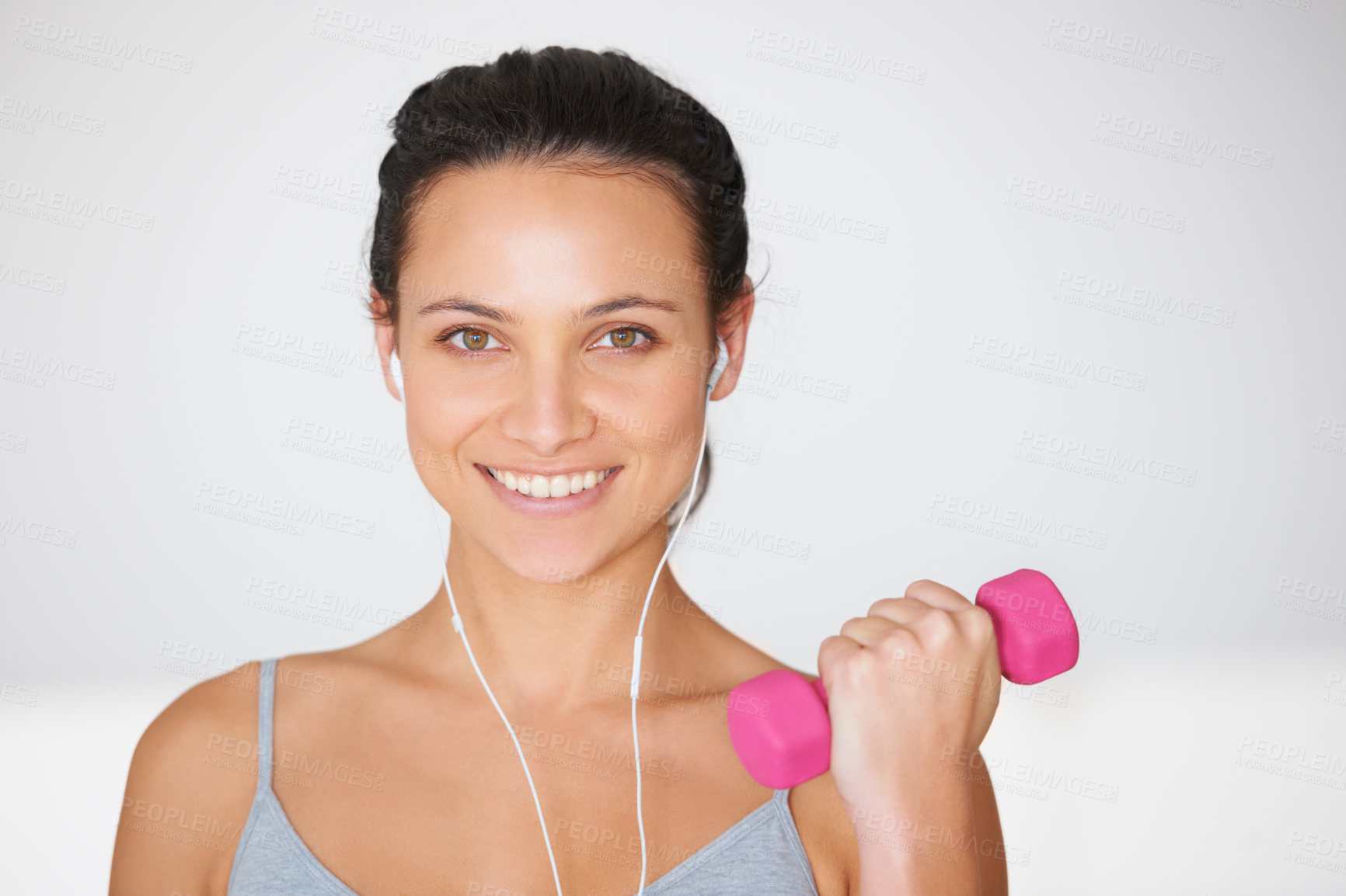 Buy stock photo Portrait of a young woman working out with weights while listening to music