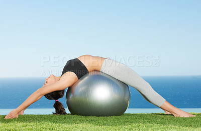 Buy stock photo Young woman using a pilates ball to stretch her back