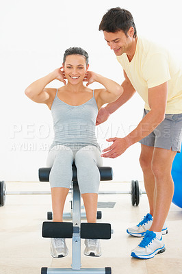 Buy stock photo Happy woman, personal trainer and sit ups on bench at gym for workout, exercise or indoor training. Man, coach or instructor helping female person on equipment for strong core or abs at health club