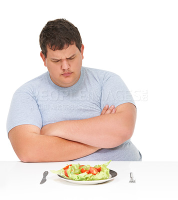 Buy stock photo Unhappy, angry and man frustrated by healthy food, meal or salad diet isolated in a studio white background. Obesity, overweight and young man with eating problem and sad for a plate with lettuce 