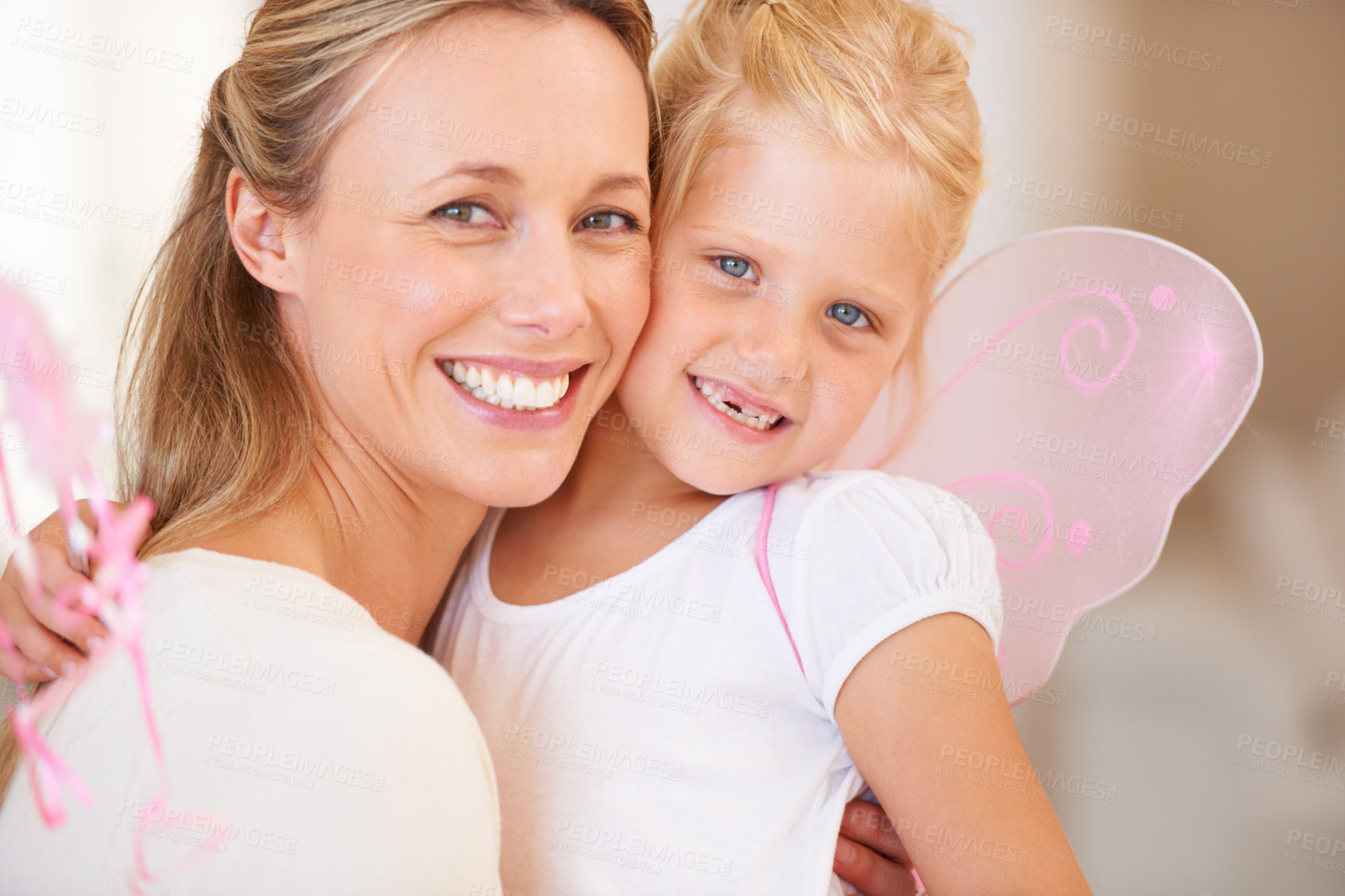 Buy stock photo A smiling mother embracing her daughter who is dressed up as a fairy