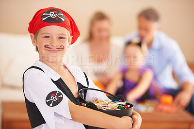 Buy stock photo Boy, portrait or candy for halloween in home, face paint or happiness in childhood. Son, chocolates and family on holiday for trick o treat, pirate costume and love in celebration together in house