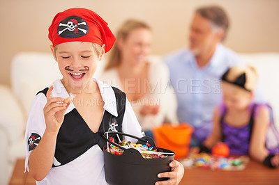 Buy stock photo Happy boy, candy and halloween in home, face paint and happiness in childhood. Son, chocolates and family on holiday event with sweets, pirate costume and love care with celebration together in house