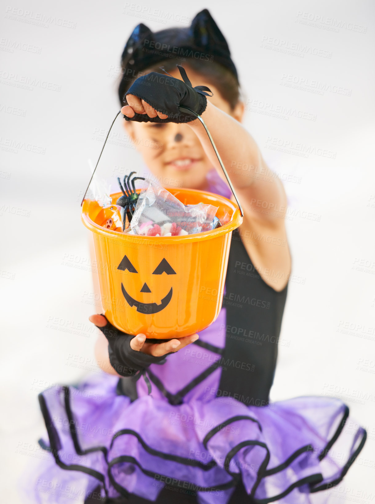 Buy stock photo Child, halloween and candy bucket for holiday fun or kid development, cat costume on white background. Young girl, smile and sweets in pumpkin as trick or treat or dress up youth, play or celebration