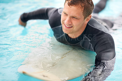 Buy stock photo Shot of a handsome young man enjoying a surf in clear blue water