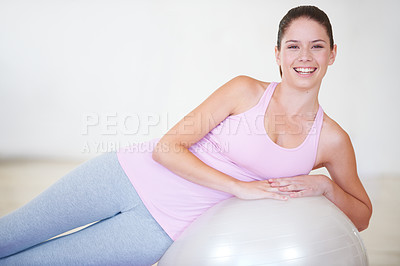 Buy stock photo Portrait of a young woman leaning on an exercise ball