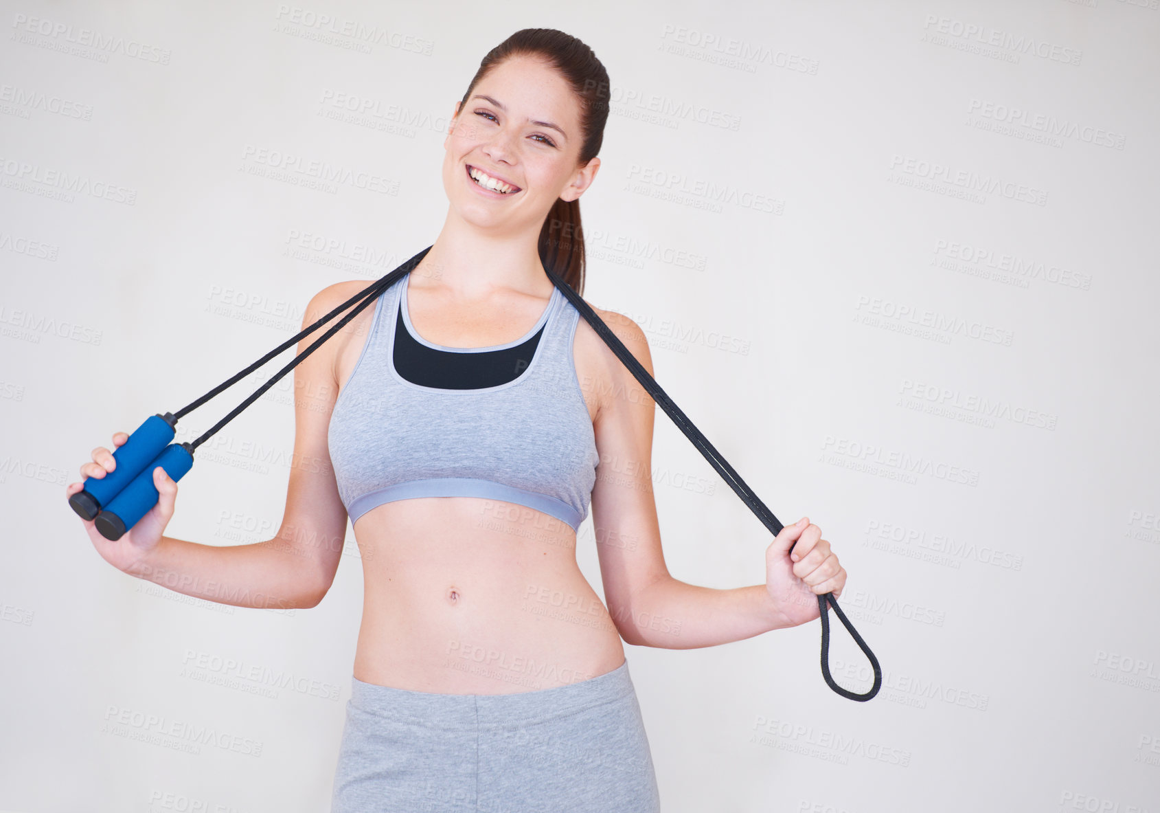 Buy stock photo Portrait of an attractive young woman holding a skipping rope over her shoulders