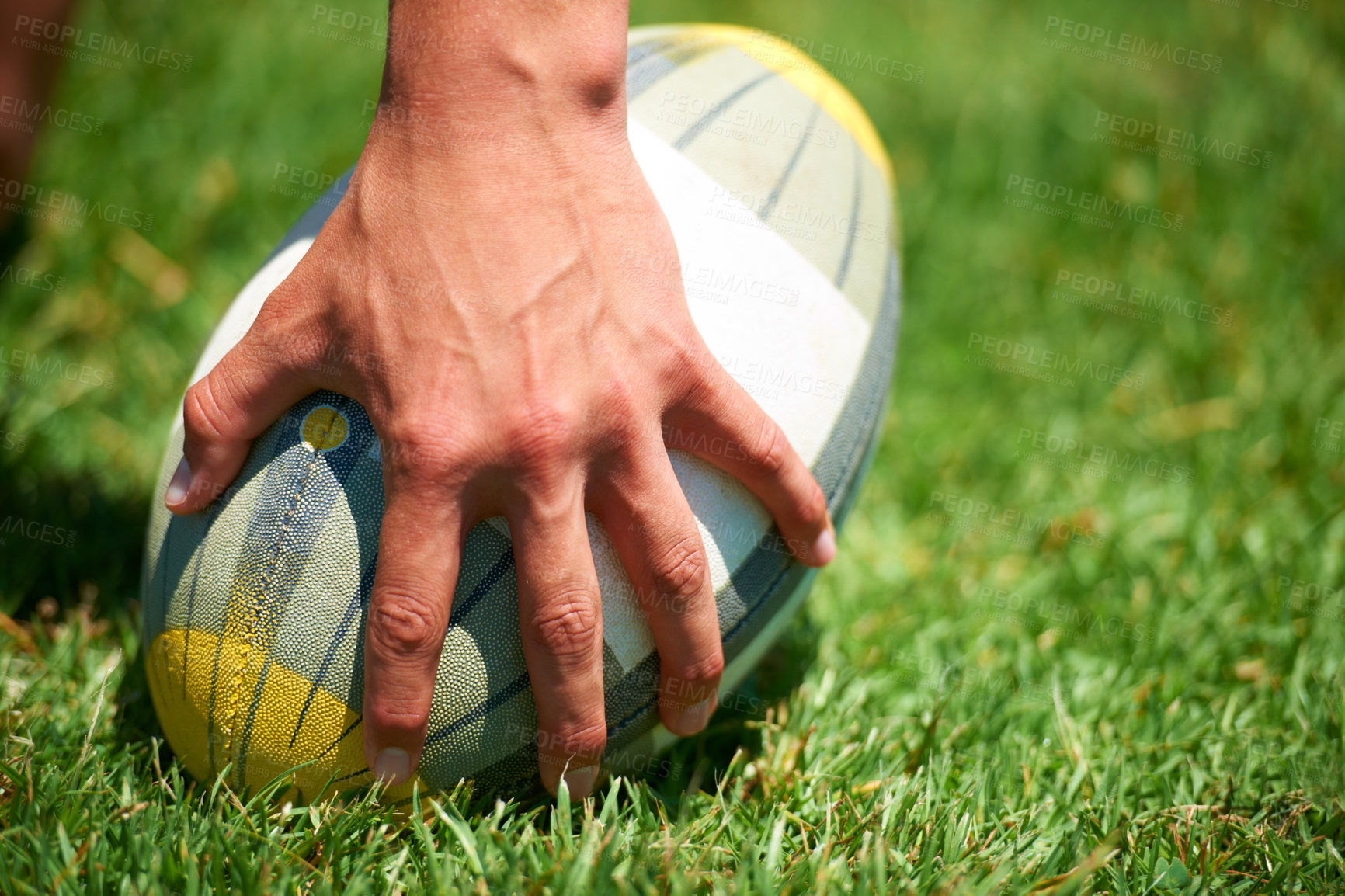 Buy stock photo Rugby player, ball sports and hand of a man while outdoor on a pitch wit green grass or lawn. Male athlete person playing in sport competition, game or training match for fitness, workout or exercise
