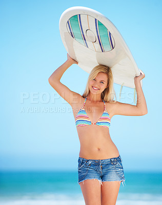 Buy stock photo A surfer girl at the beach holding up her surfboard getting ready to surf