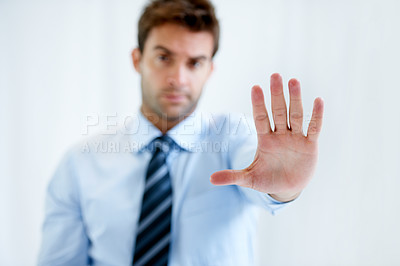 Buy stock photo Portrait of a businessman with a stern expression and holding up his hand in a stop motion