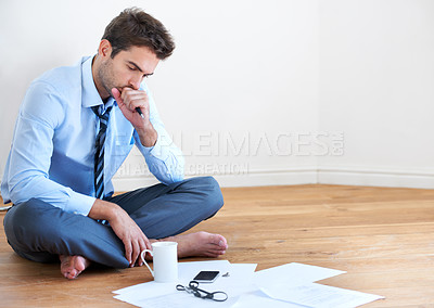 Buy stock photo Stress, documents and finance with a business man reading tax paper or a budget on the floor of his apartment. Accounting, compliance and anxiety with a young employee looking worried about debt