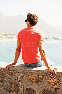 Buy stock photo Relax, fashion and man by ocean in city for summer holiday, vacation and weekend outdoors. Sunglasses, travel and back of person by sea in trendy clothes, style and casual outfit for adventure