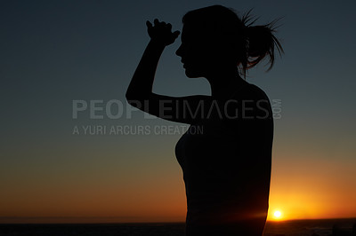 Buy stock photo Silhouette of a young woman looking into the distance against a setting sun