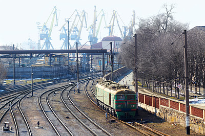 Buy stock photo Shot of a train on the tracks with industry in the background