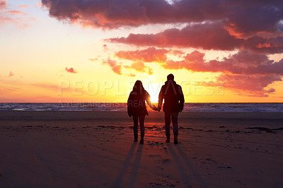Buy stock photo Silhouette of a couple going for a walk on the beach at sunset