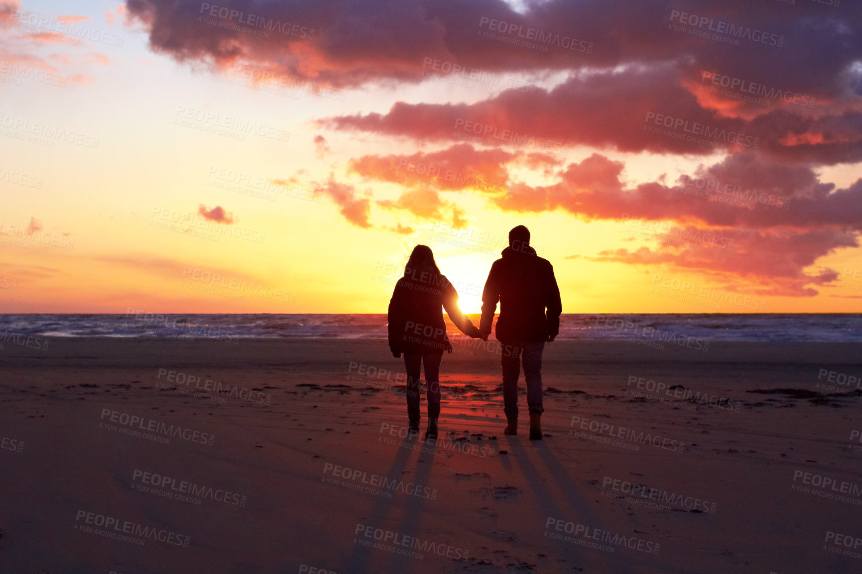 Buy stock photo Silhouette of a couple going for a walk on the beach at sunset