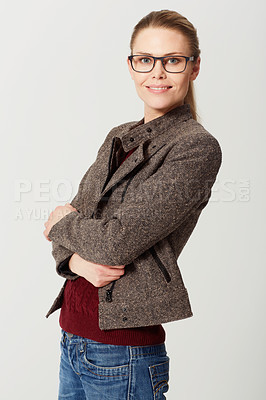 Buy stock photo Cropped studio portrait of a happy and attractive young woman standing with her arms folded