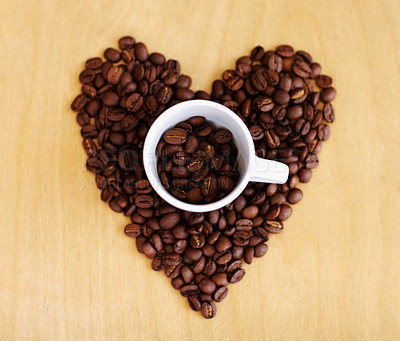 Buy stock photo Heart, roasted coffee beans and cafe industry with love icon or emoji for marketing and advertising. Above wooden table or background with grain shape as drink, espresso or caffeine ingredient