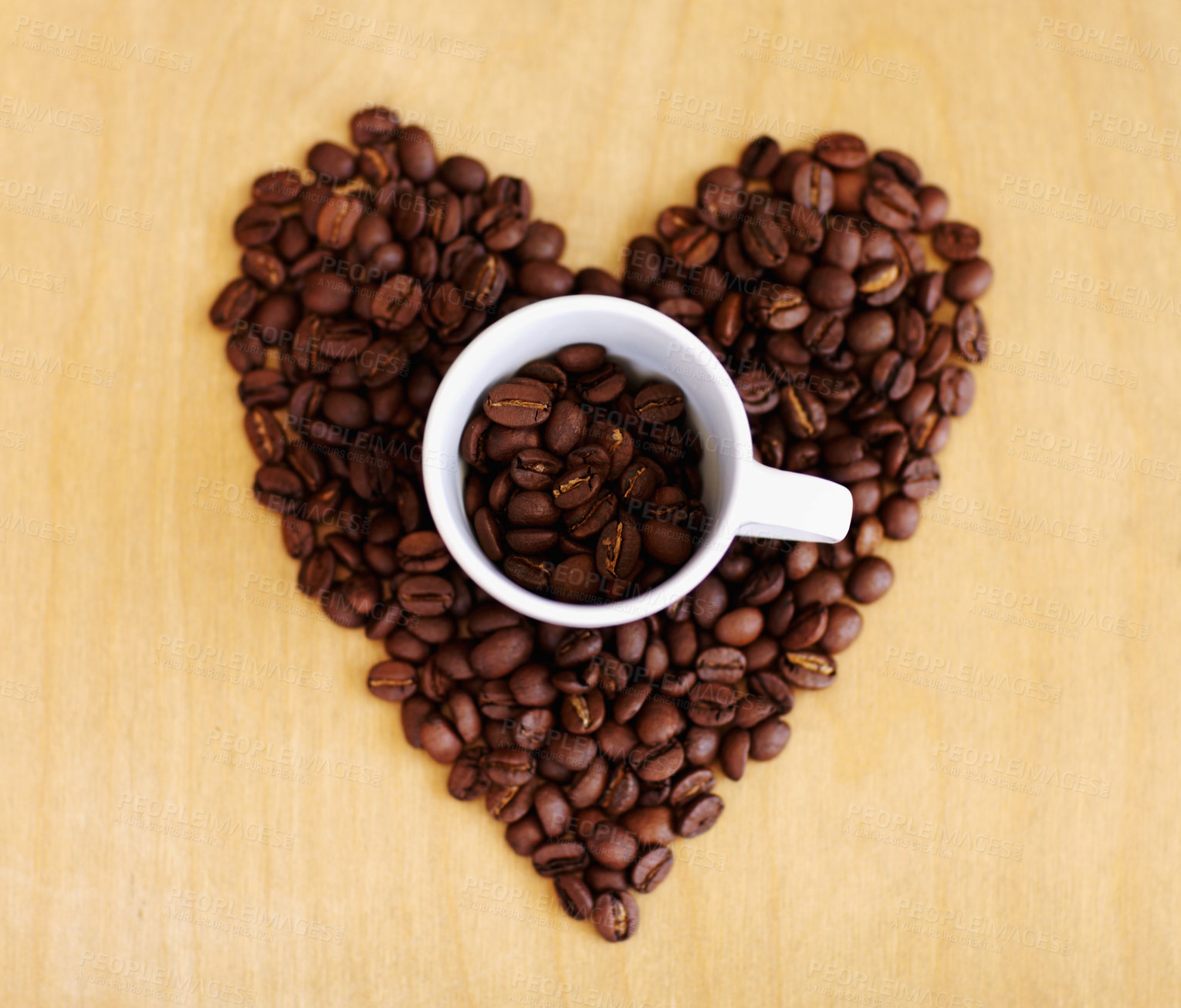 Buy stock photo Heart, roasted coffee beans and cafe industry with love icon or emoji for marketing and advertising. Above wooden table or background with grain shape as drink, espresso or caffeine ingredient