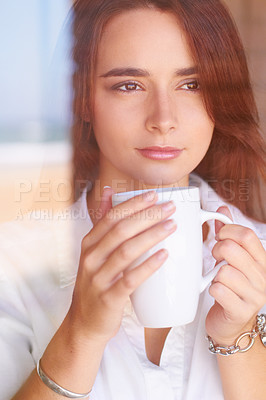 Buy stock photo A young woman looking thoughtful while drinking her morning coffee