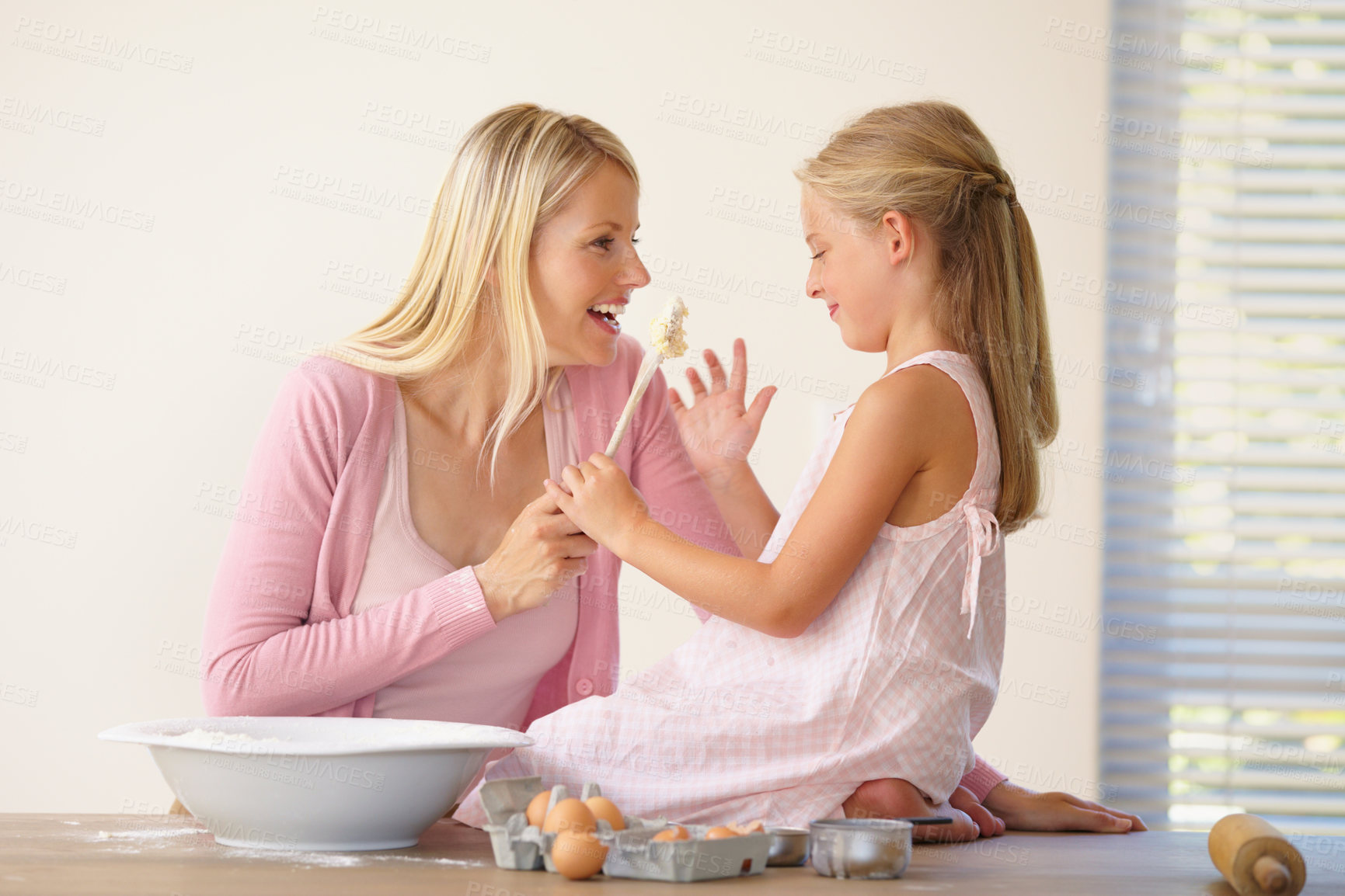 Buy stock photo A mother and daughter having fun and joking around while baking together
