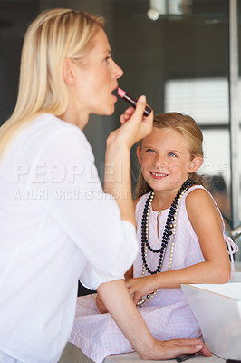 Buy stock photo Little girl watching her mother apply her make-up