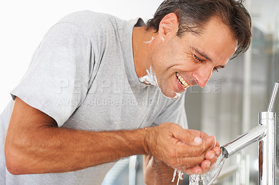 Buy stock photo A mature man washing his face in the basin