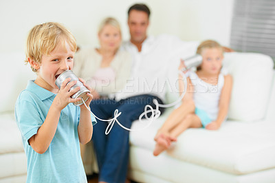 Buy stock photo A little boy shouting loudly into a tin can connected to another that his sister is holding