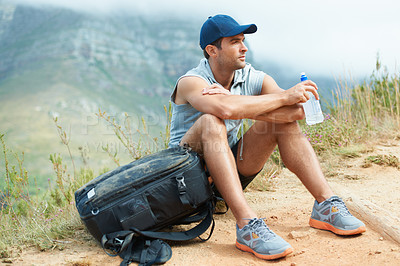 Buy stock photo Young hiker sitting down and taking a moment to rest