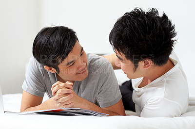 Buy stock photo Cute young gay Asian couple smiling while relaxing at home together