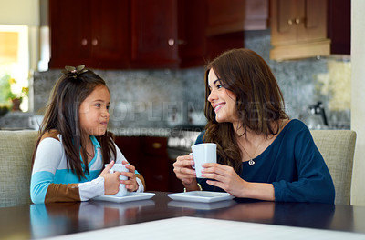 Buy stock photo Sweet little girl sharing a hot chocolate with her mother at home