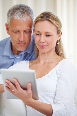 Buy stock photo A married couple sharing a digital tablet at home