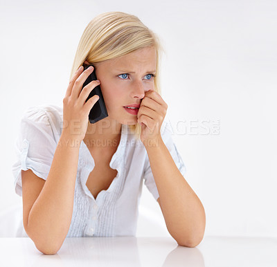 Buy stock photo Shot of an attractive woman looking worried while talking on her cellphone