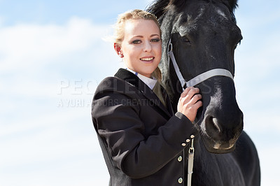 Buy stock photo Low angle portrait of a young female rider hugging her horse affectionately