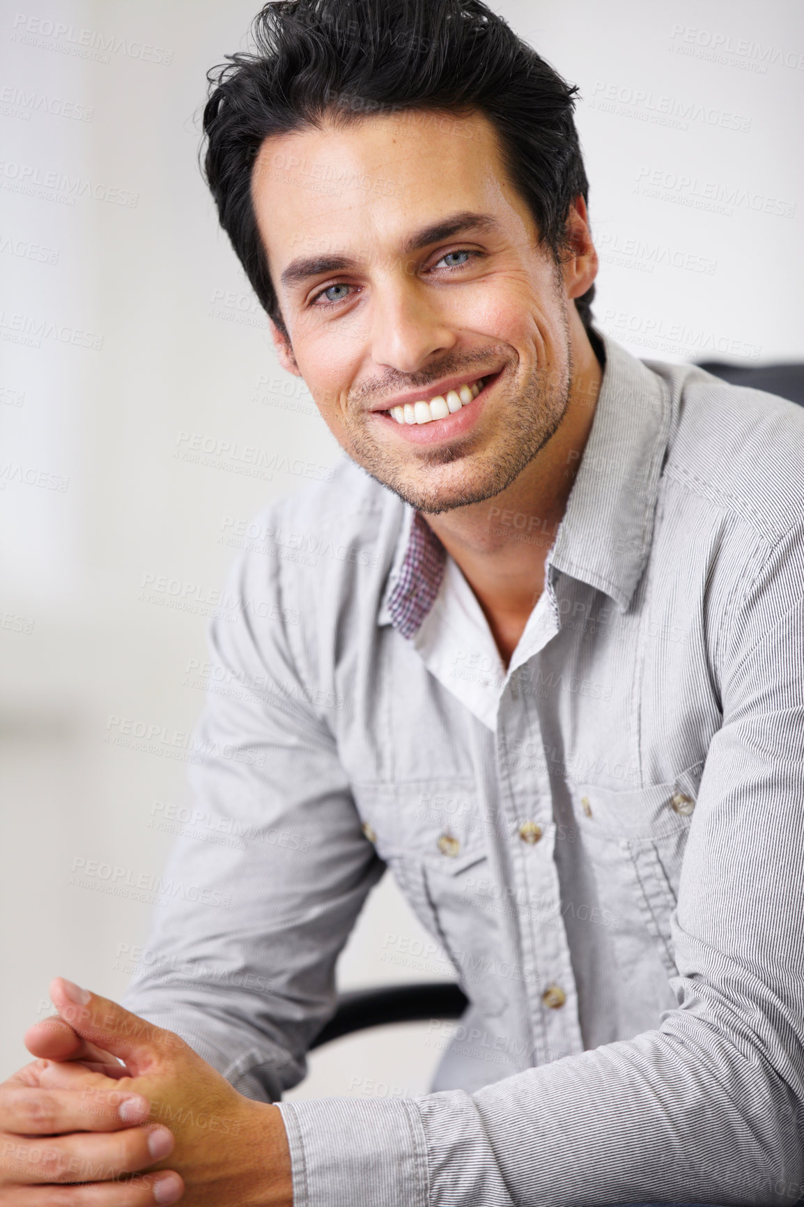 Buy stock photo Shot of a handsome young sitting in a chair