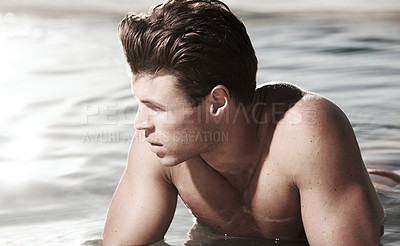 Buy stock photo A contemplative male model lying in water
