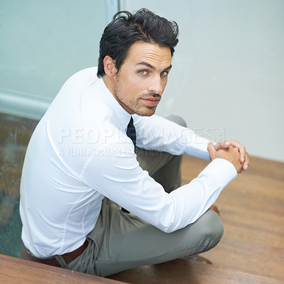 Buy stock photo A handsome young businessman sitting on a staircase