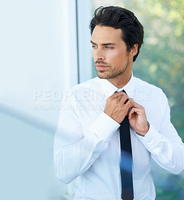 Buy stock photo A handsome young businessman adjusting his tie