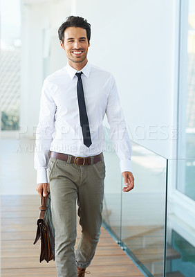Buy stock photo A handsome young businessman walking with his suitcase