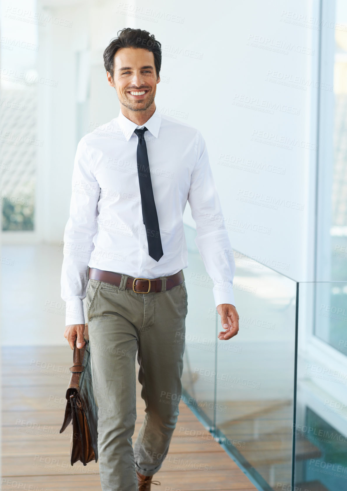 Buy stock photo A handsome young businessman walking with his suitcase