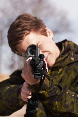 Buy stock photo A young soldier aiming his rifle at you