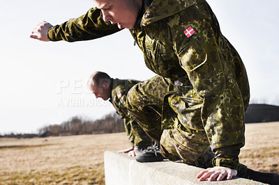Buy stock photo Soldier in training, military men and jump over a wall in obstacle course for fitness and endurance. Army team in camouflage uniform outdoor, train for war and exercise with mission and action